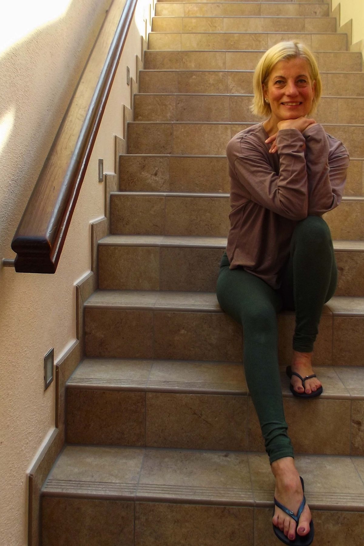 Korinna Schroll sitzt entspannt auf einer Treppe